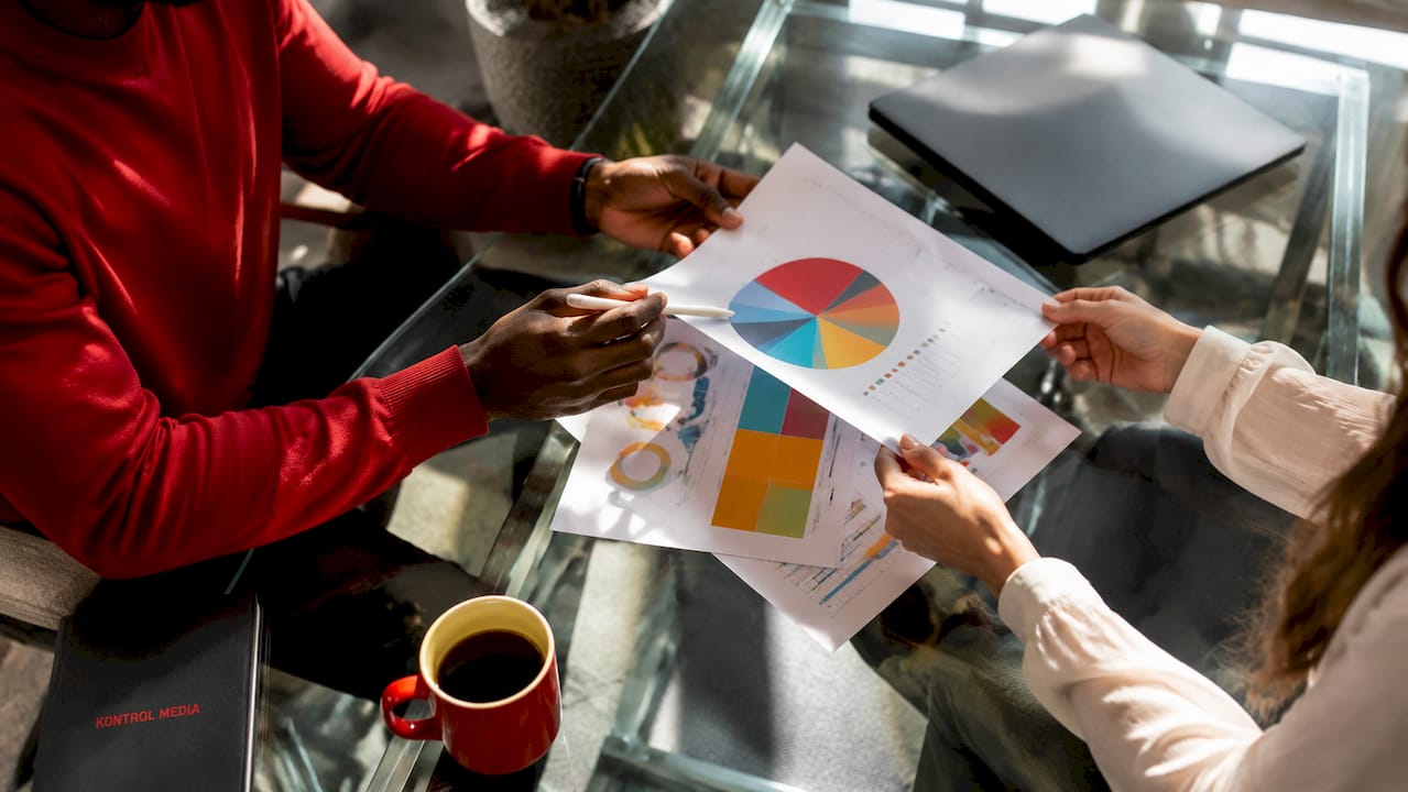 Hands exchanging charts on demand generation tactics
