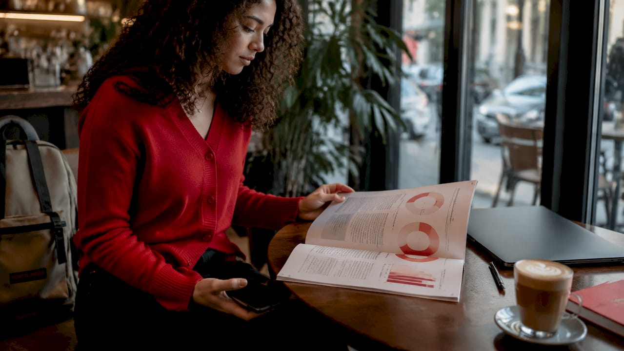Hands holding smartphone next to moving demographic report