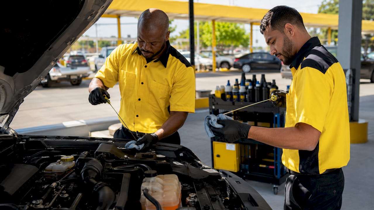 Close-up of hands checking car fluids under hood