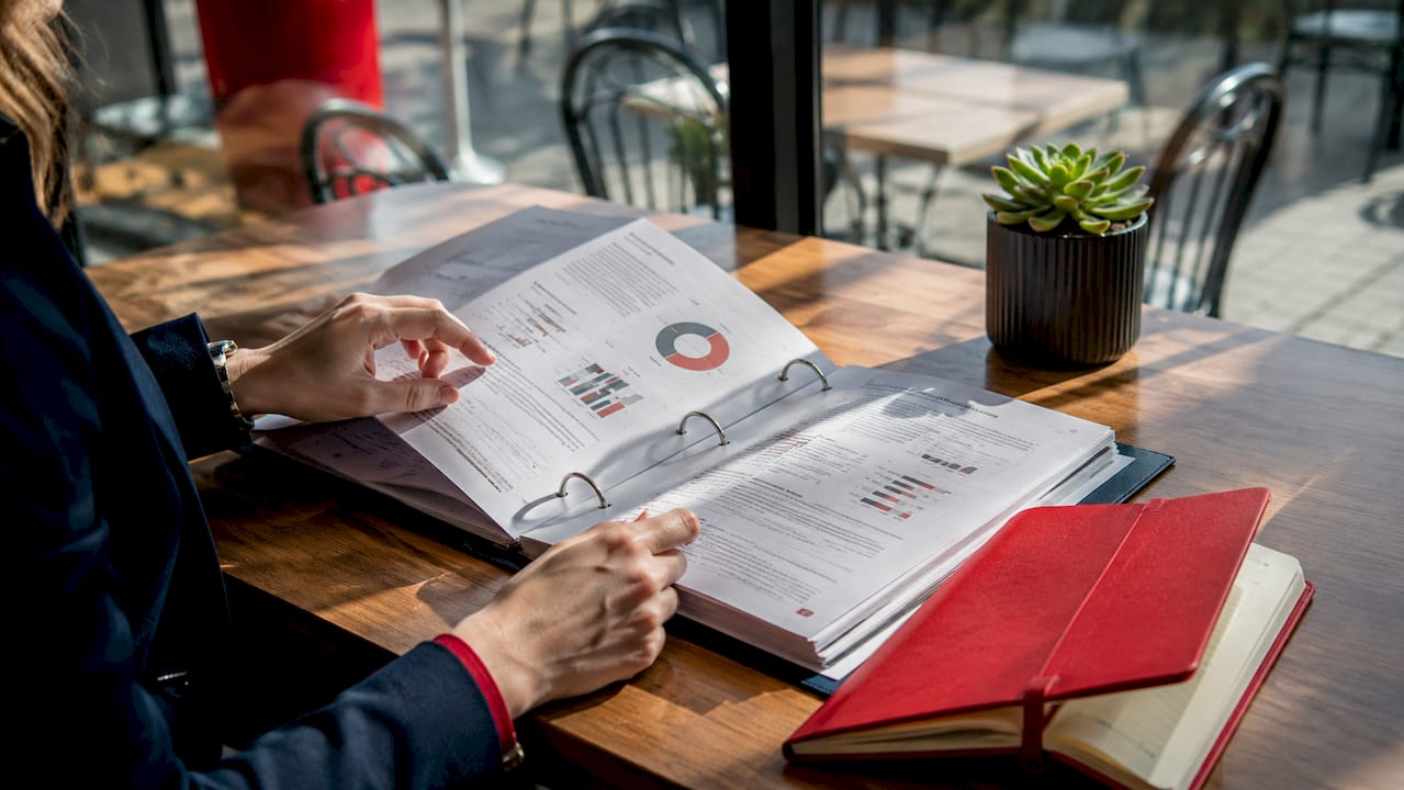 Hands flipping pharmaceutical regulatory binder pages