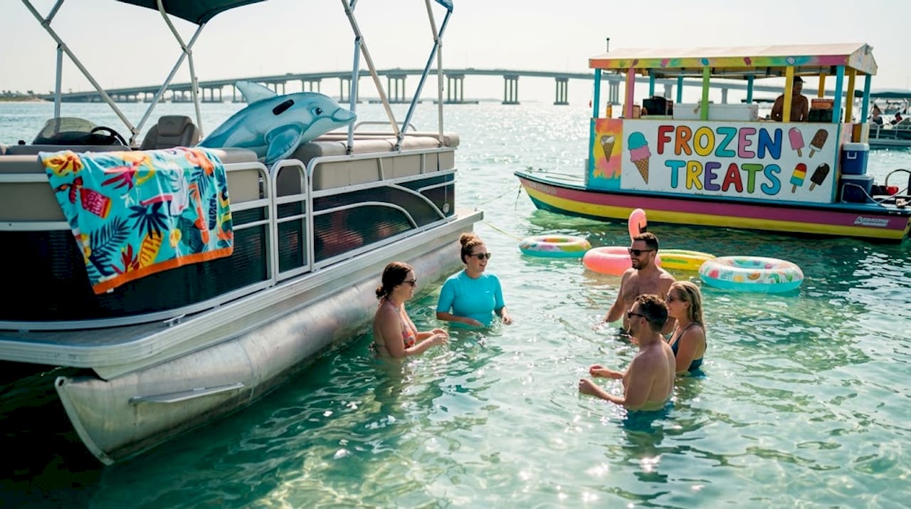 People relaxing by boat at Crab Island sandbar