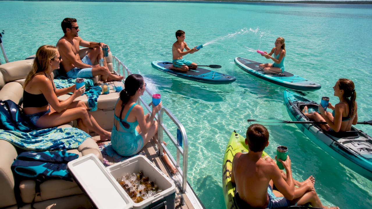 Family enjoying anchored pontoon boat at sandbar