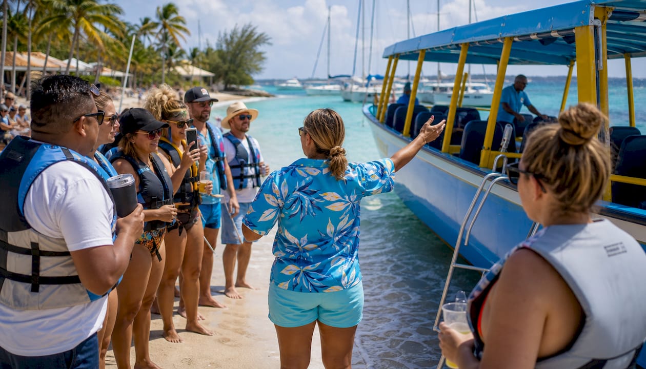 Vacationers receiving boat tour safety briefing on dock