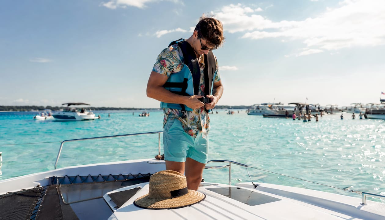 Man puts on life jacket on Destin boat deck