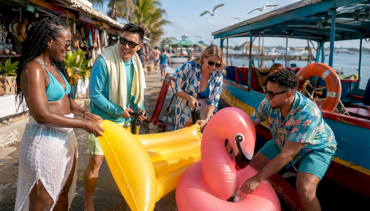 Group boarding boat with colorful floats at marina