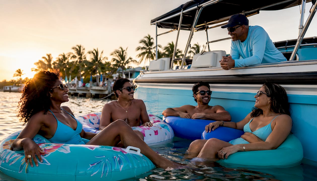 Friends relaxing on floats during boat tour