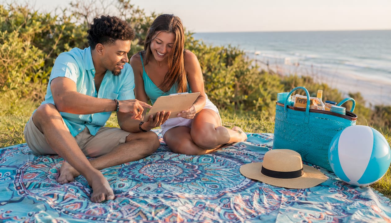 Couple planning beach date checklist outdoors