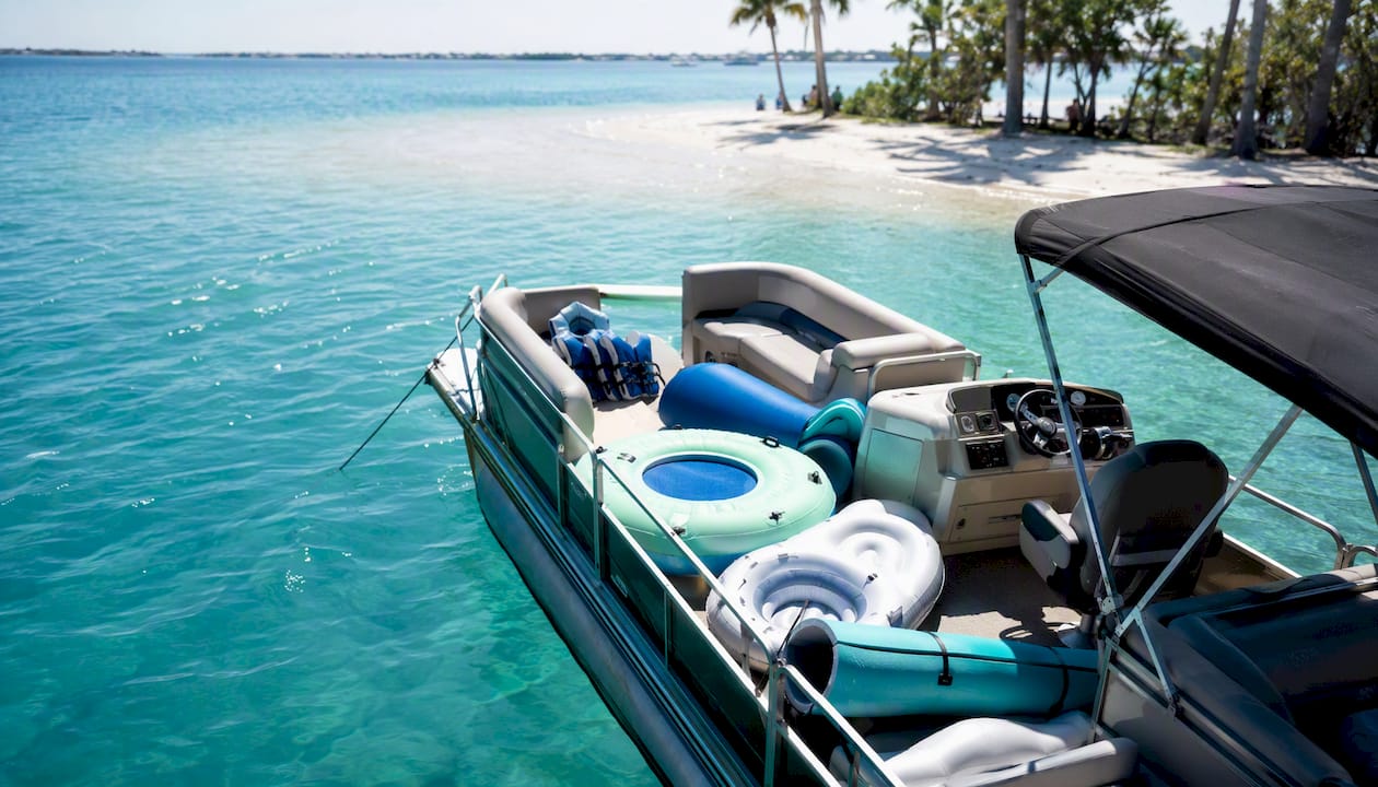 Captain-led boat anchored near sandbar with floats