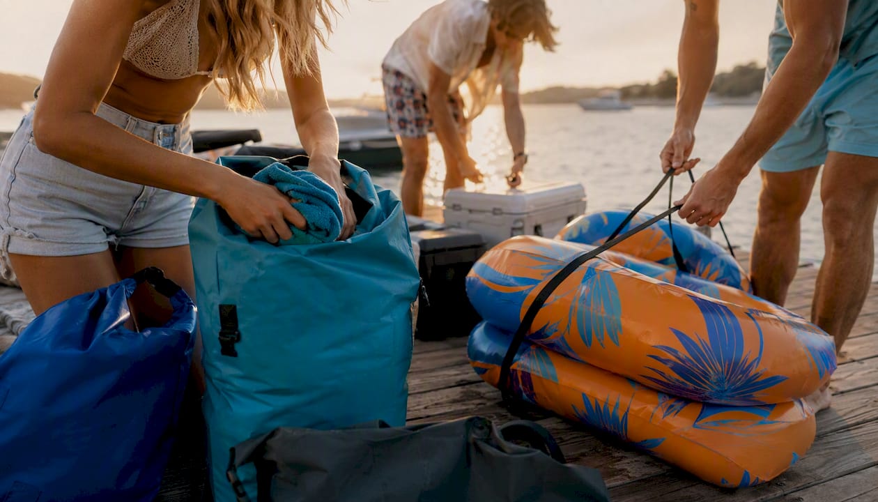 Hands packing coolers and floats for group boat trip