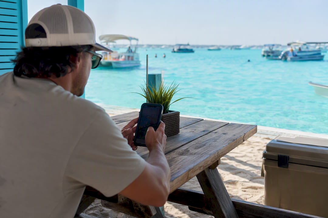 Person checking water conditions on phone near water