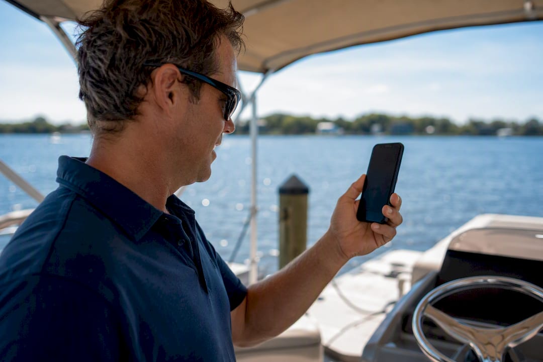Boat captain checking data on phone at dock