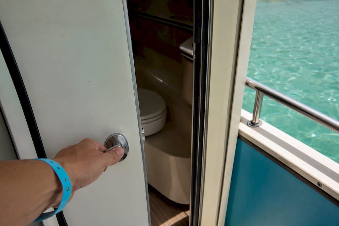 Hand opening boat restroom door onboard