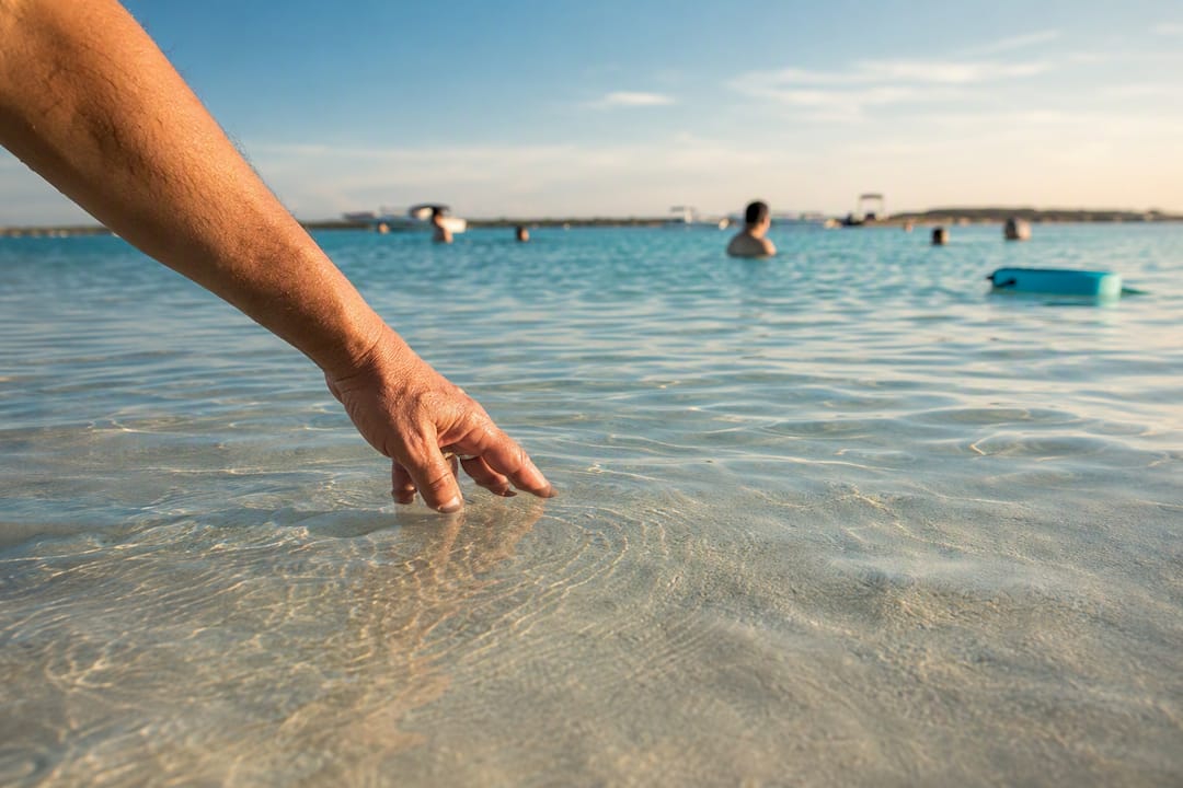 Hand testing Crab Island sandbar water