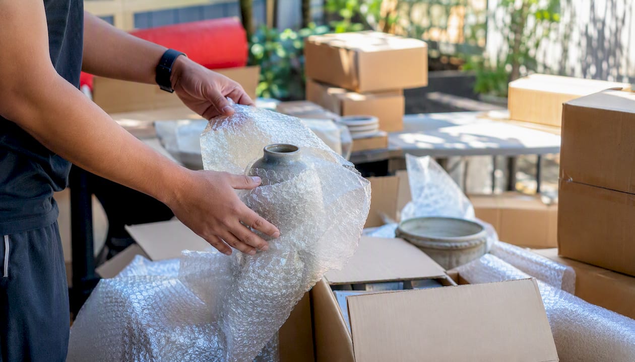 Hands wrapping and labeling boxes