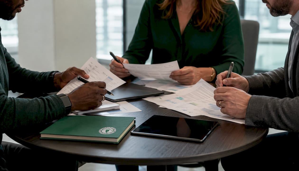 Hands collaborating on IT governance documents