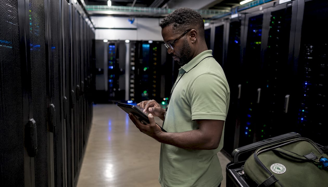 Technician managing servers in cloud infrastructure room