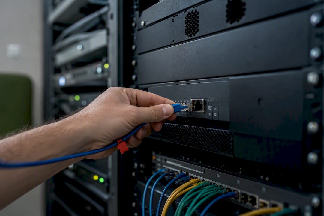 Hands connecting tagged cable for temporary firewall rule