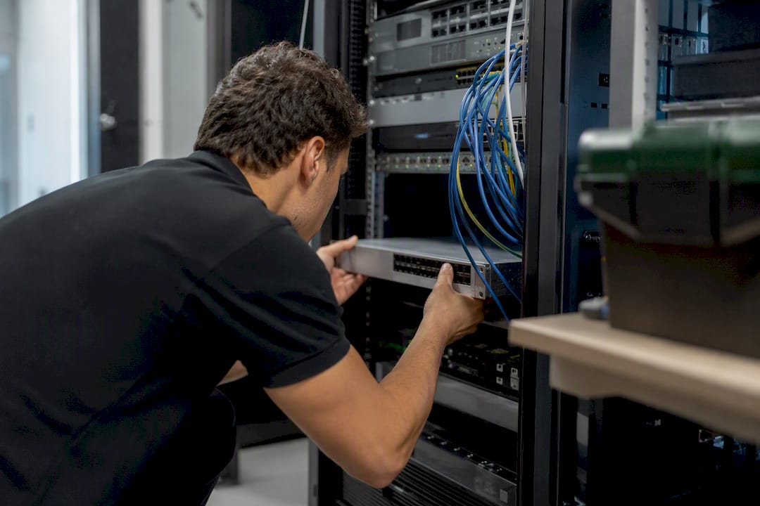 Hands installing security device on network in server room