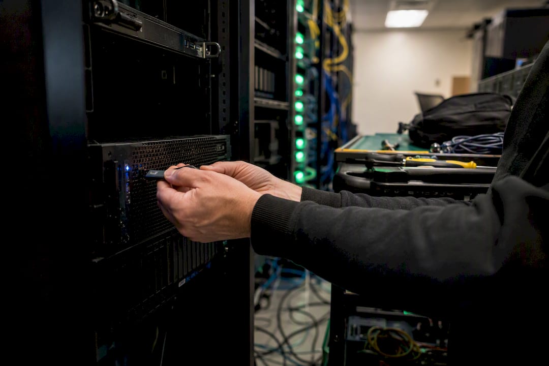 Hands plugging USB security device in server room
