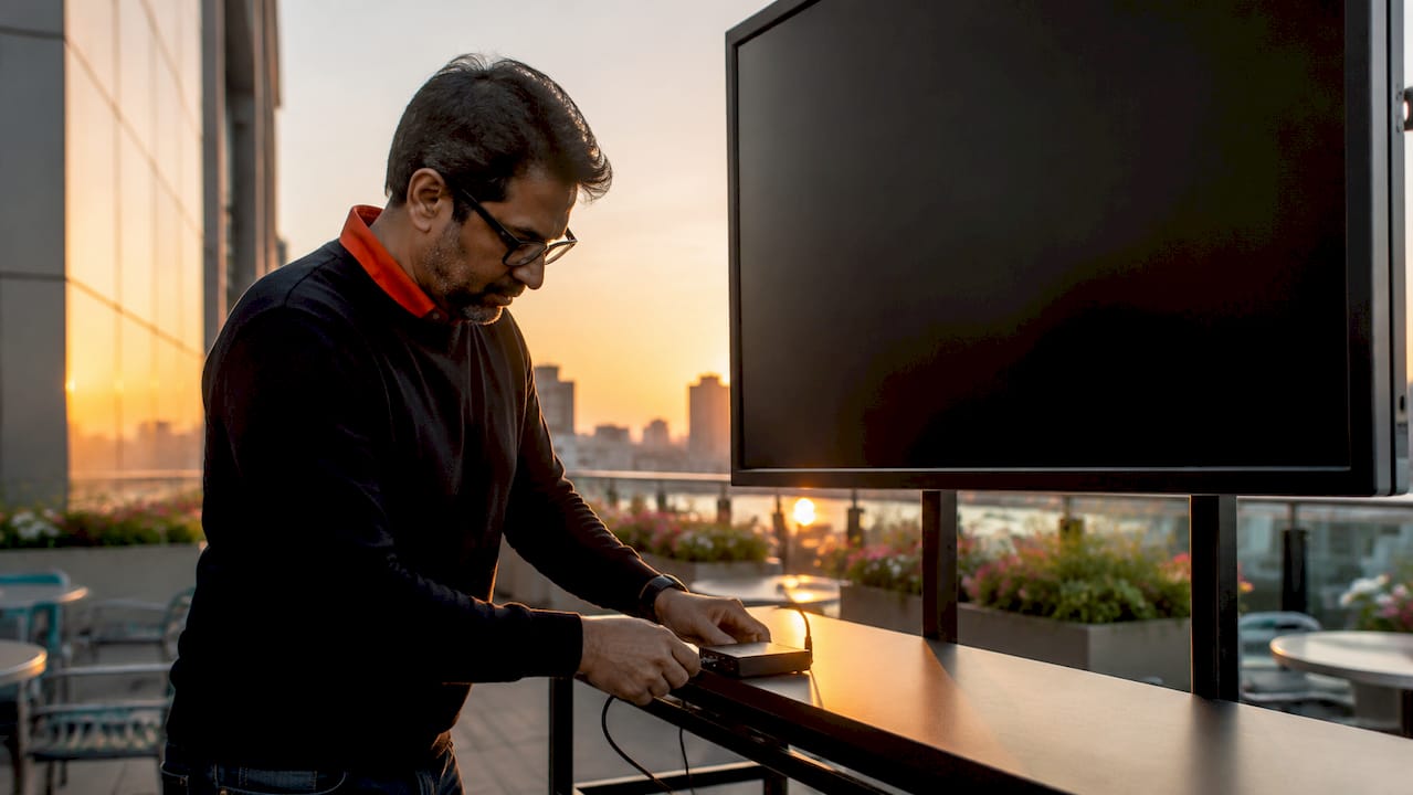 Man setting up digital signage device in office lobby