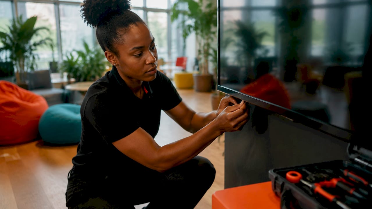 Technician adjusting mounted digital signage screen