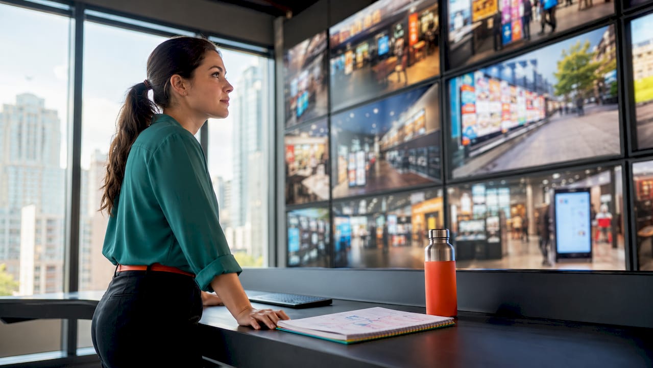 Marketing manager monitoring multi-location screens