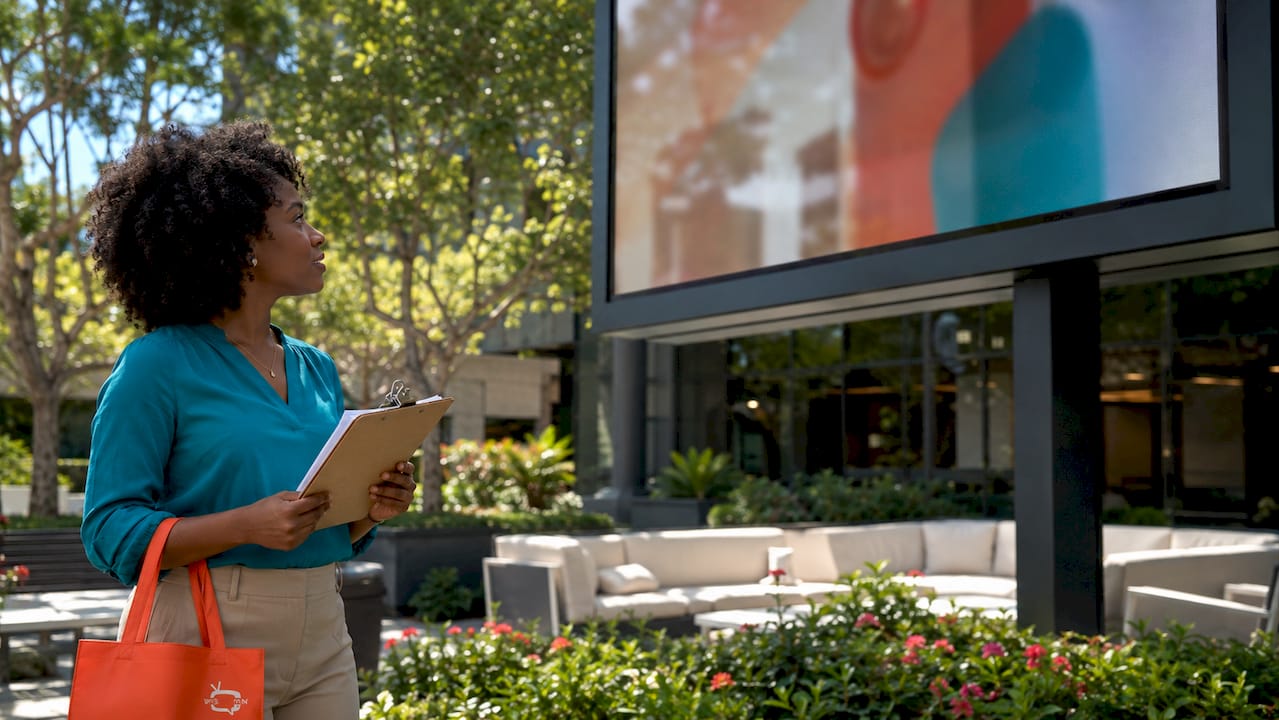 HR coordinator reviewing digital signage onboarding display