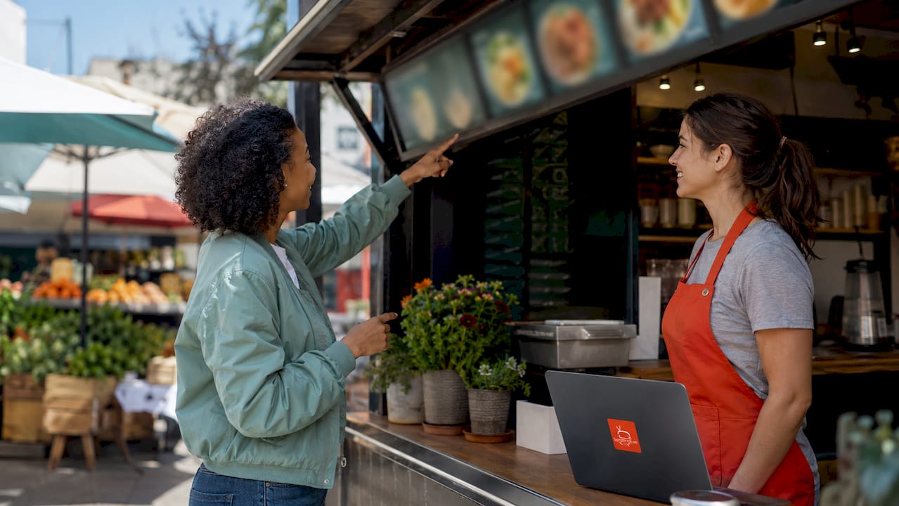 Customer pointing at digital menu board