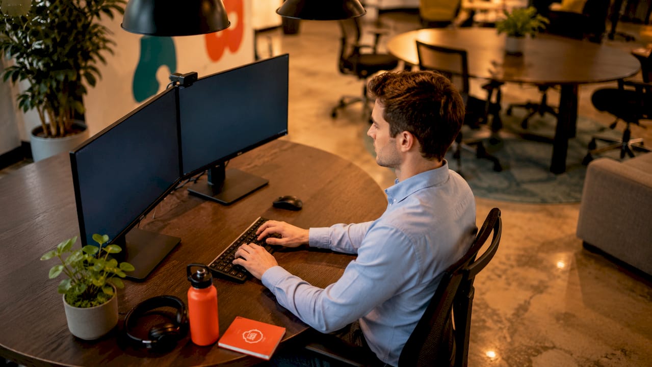 Employee working at ergonomic dual monitor setup