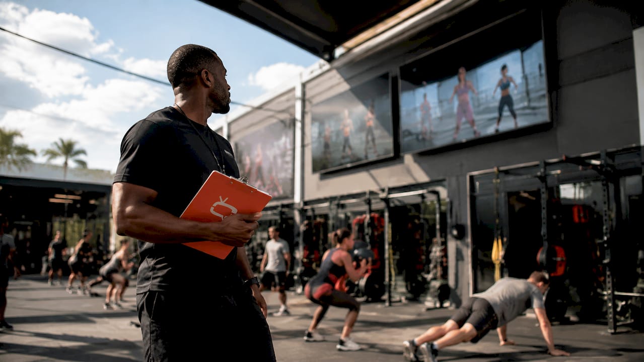 Gym manager inspecting digital screens during busy hours
