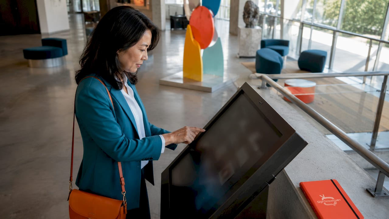 Woman using wayfinding touchscreen kiosk in museum