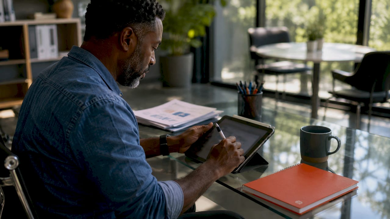 Hands managing content on tablet in office