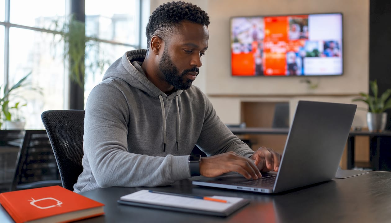IT manager managing signage scaling on laptop