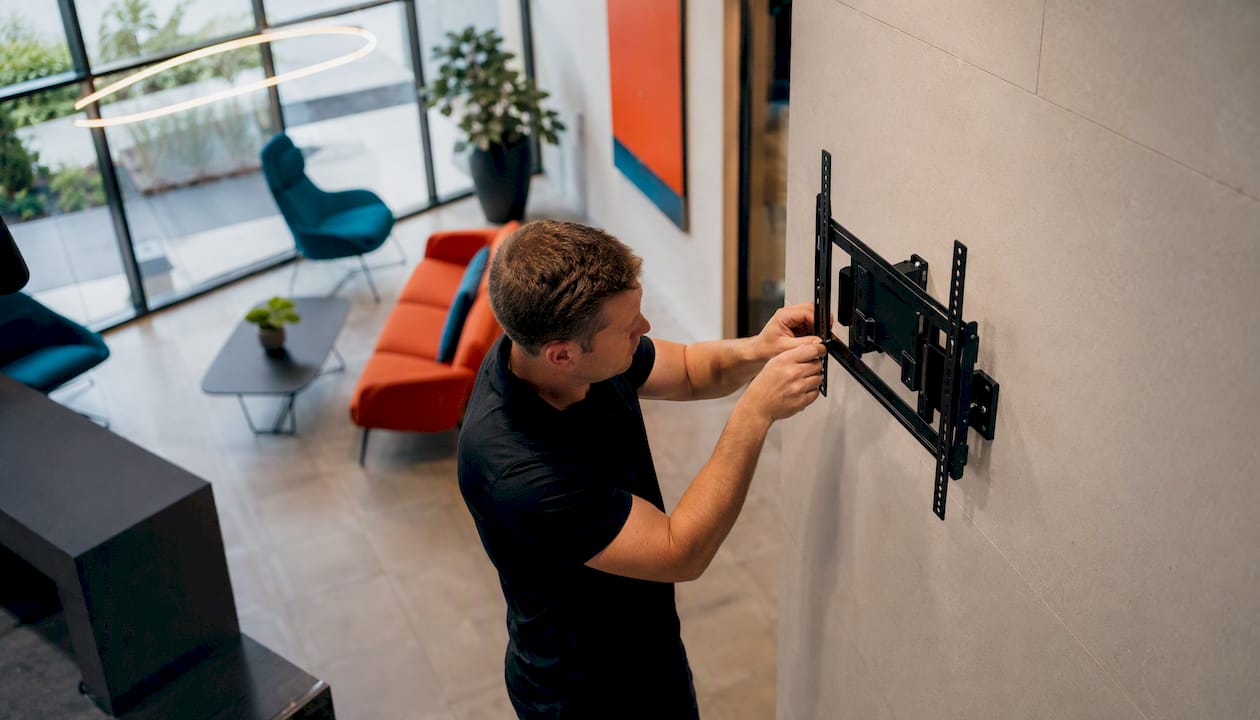 Installer mounting digital signage bracket