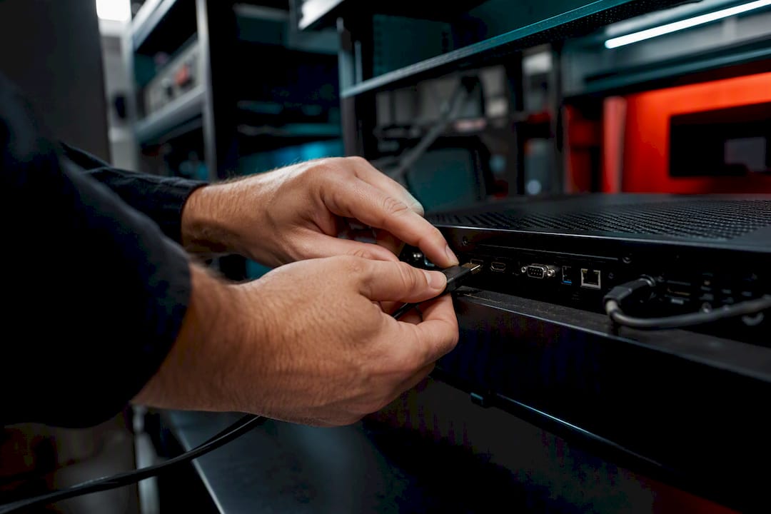 Hands reconnecting HDMI cable on signage player