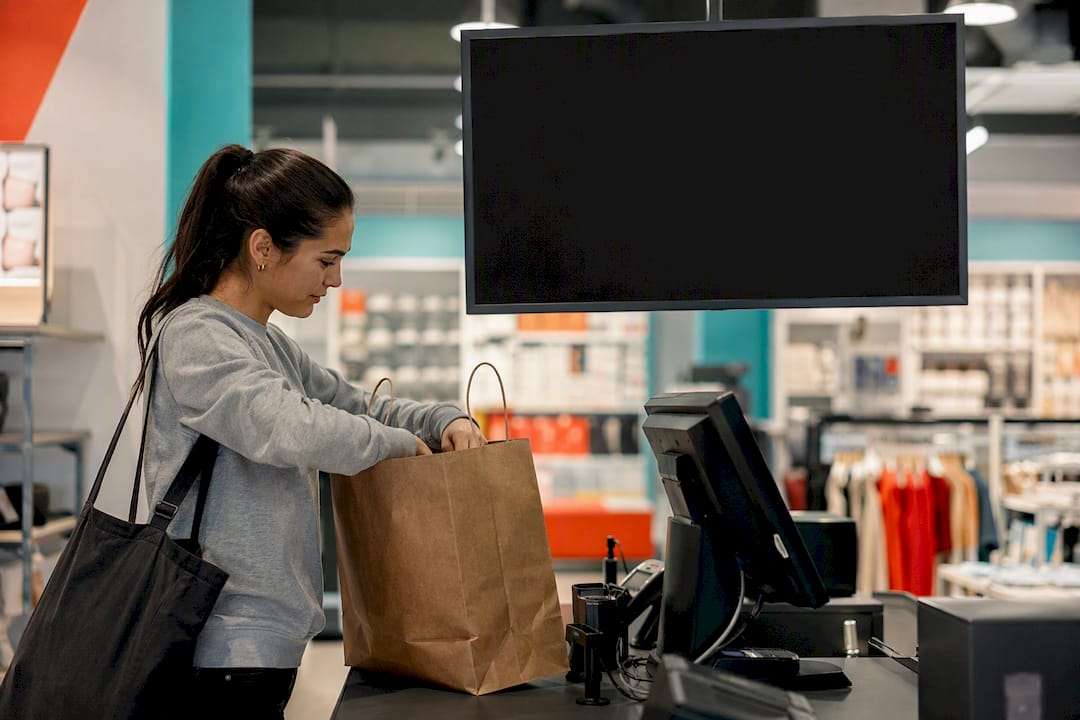 Retail checkout with digital signage and shopper hand