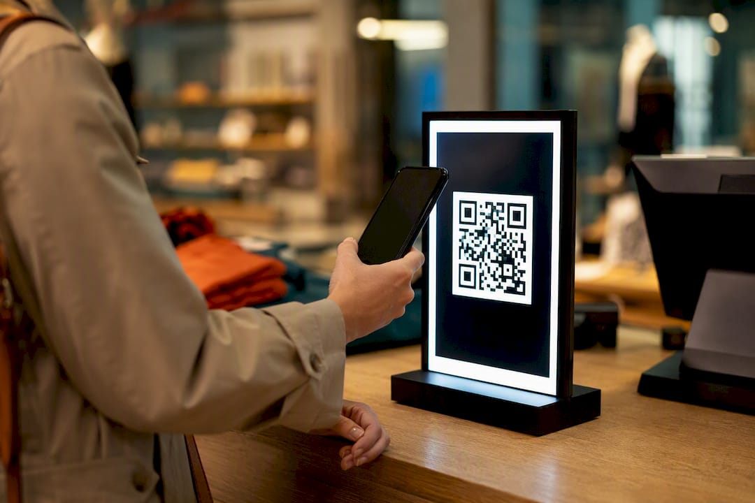 Hands scanning QR code on digital loyalty sign