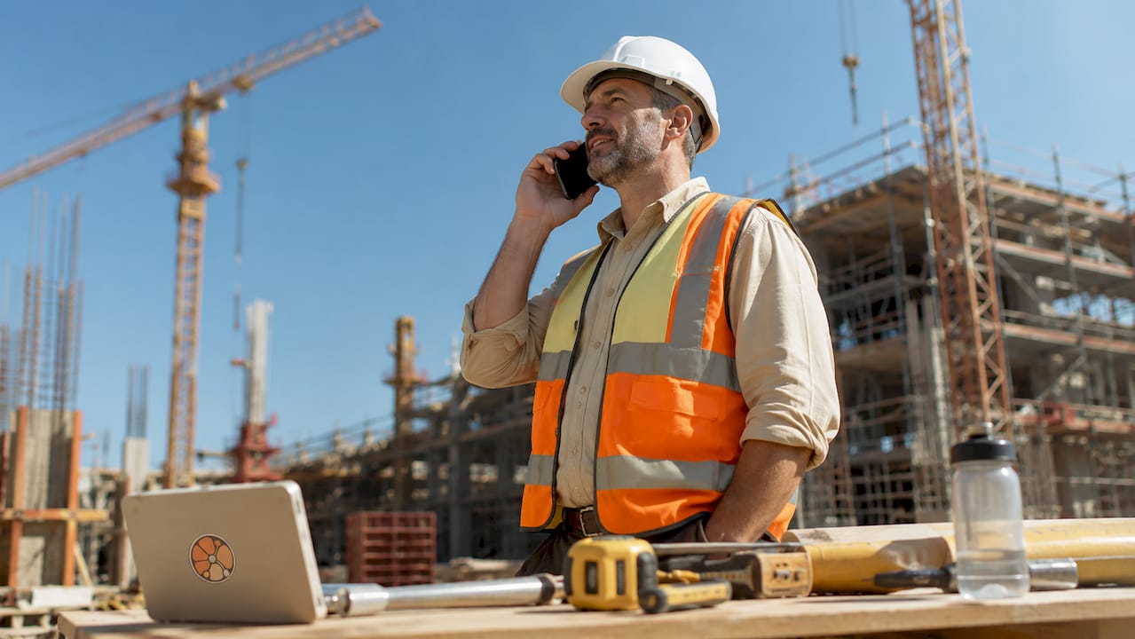 Contractor using smartphone at construction site