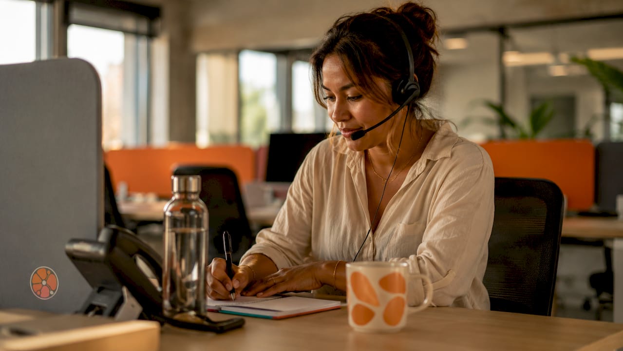 Customer service agent taking calls at desk
