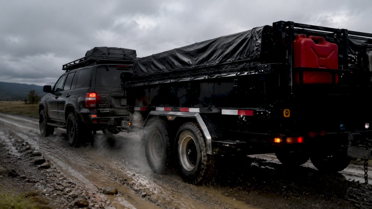 SUV towing trailer on desert deployment road