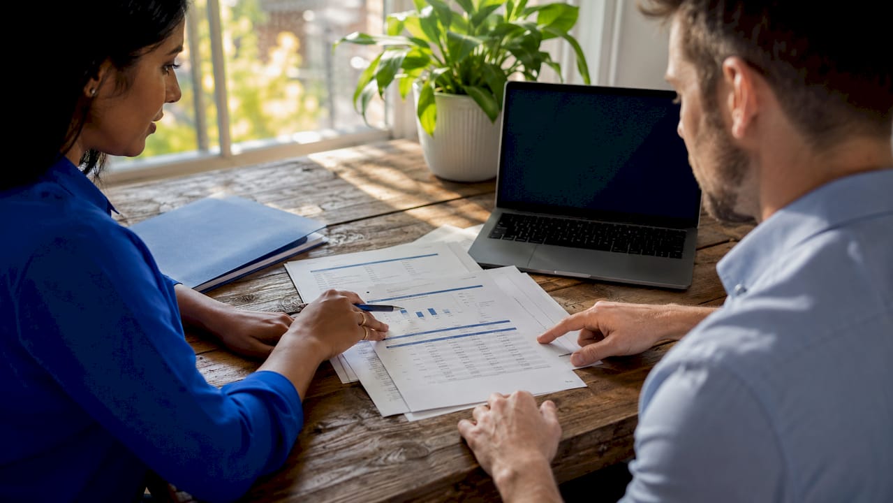 Hands reviewing rental income and expense reports
