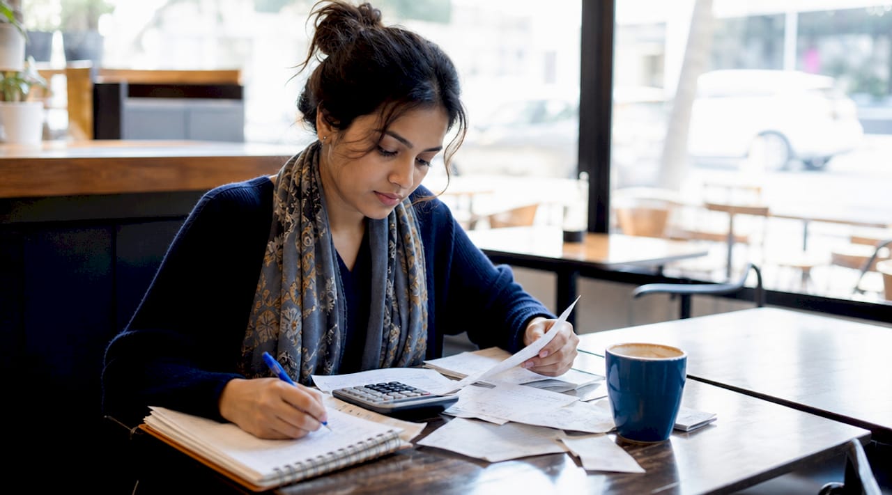 Woman reviewing personal finances at kitchen table