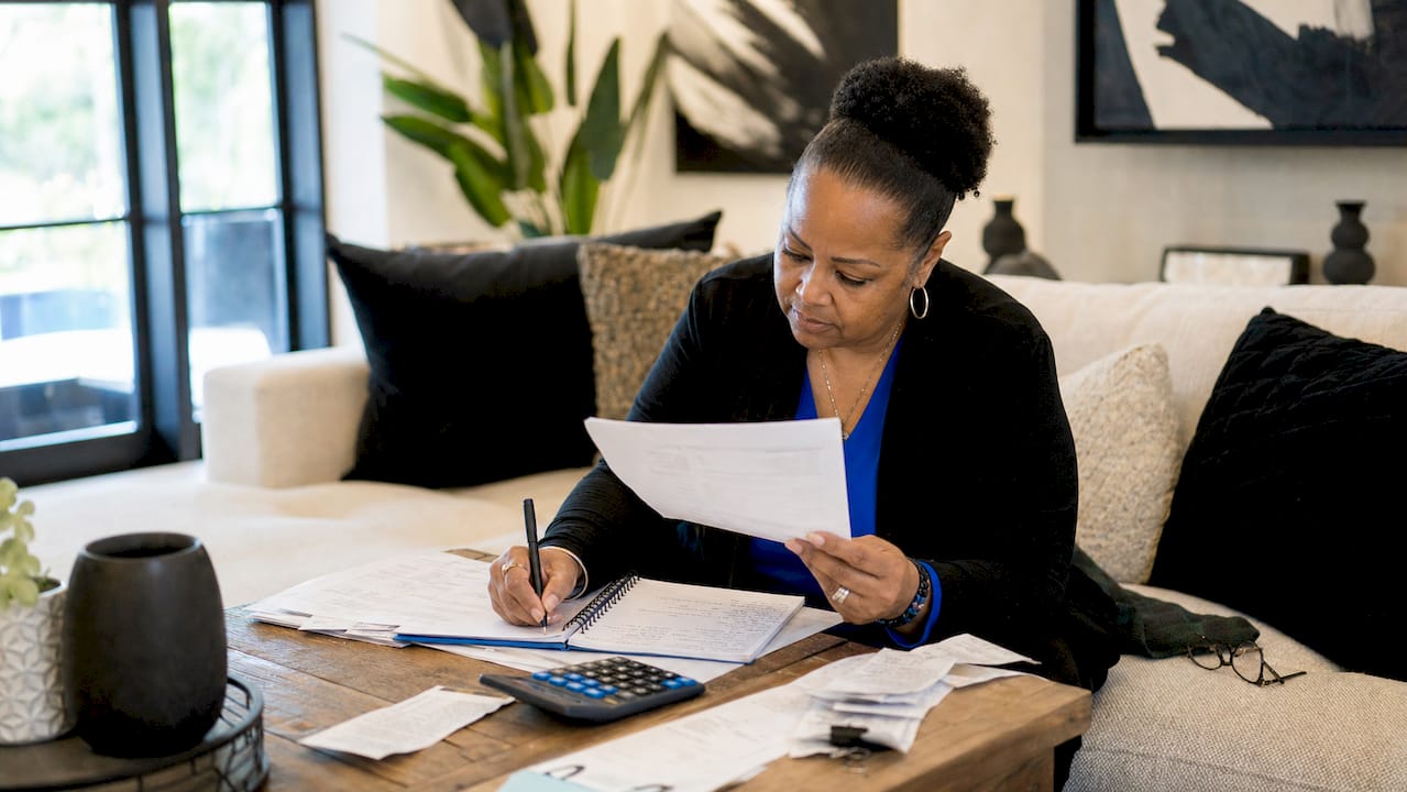 Landlord reviews rental income paperwork at home table