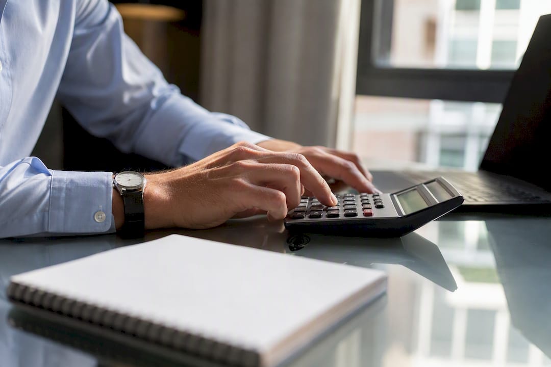 Hands calculating late fee on calculator