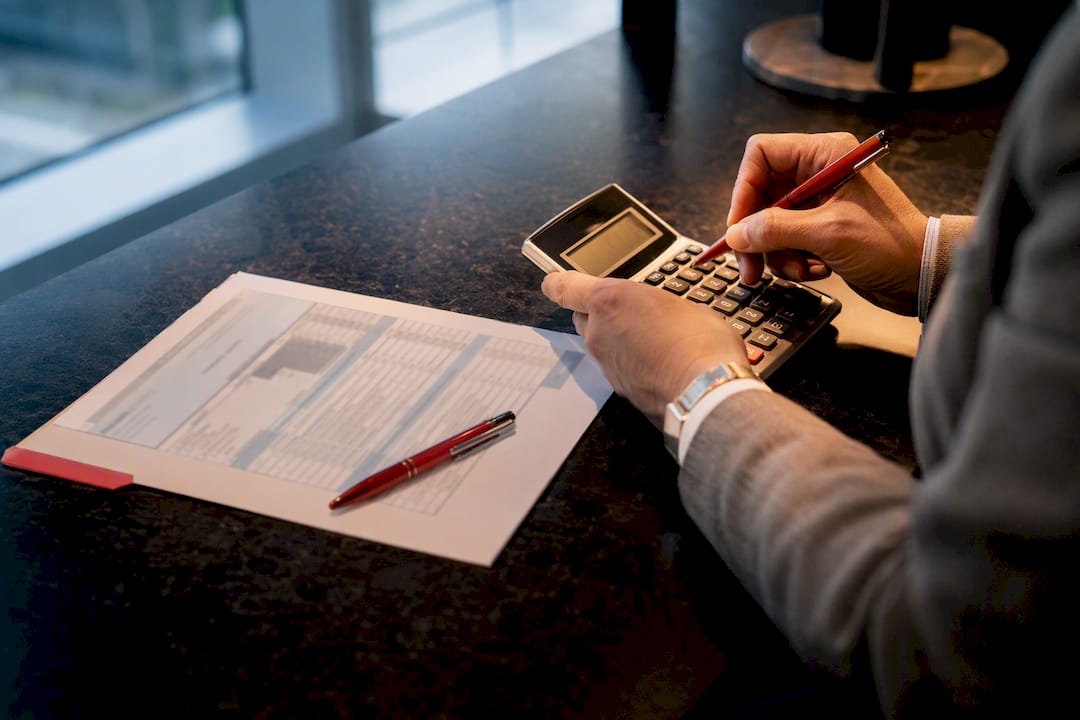 Hands calculating HAP beside rental worksheet