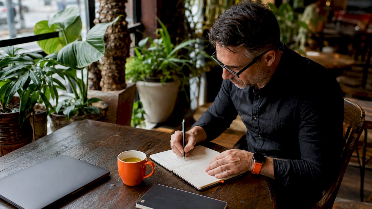 Man journaling in home study with morning light