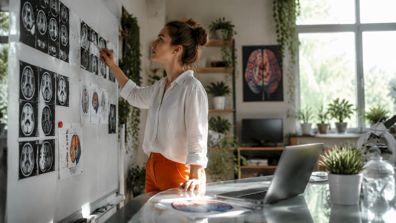 Neuroscientist reviewing brain scan images at desk