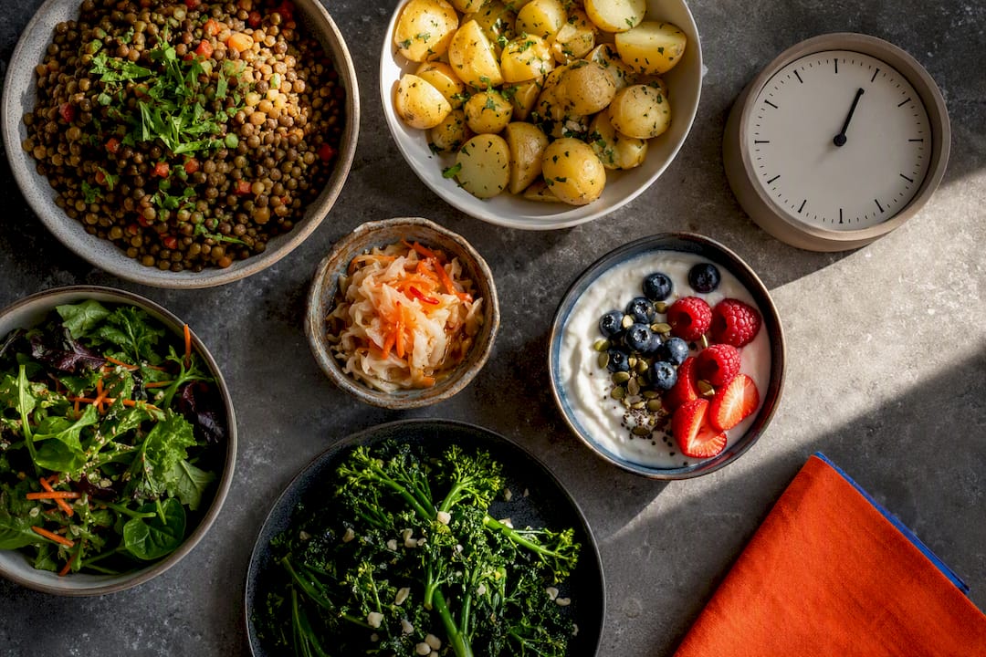 Fiber-rich foods arranged around meal timing clock