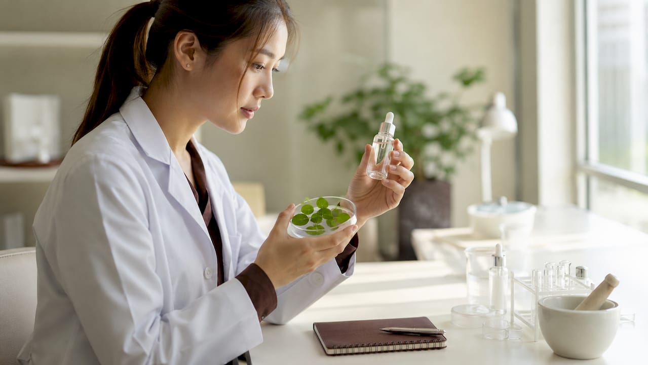 Detailopname van handen met Centella asiatica en een verzorgend serum