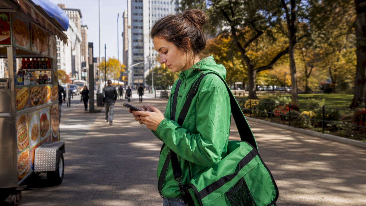 Delivery driver selecting orders on smartphone